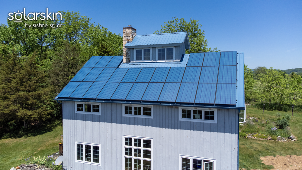 Solar panels on the roof blend in with the blue metal roof 